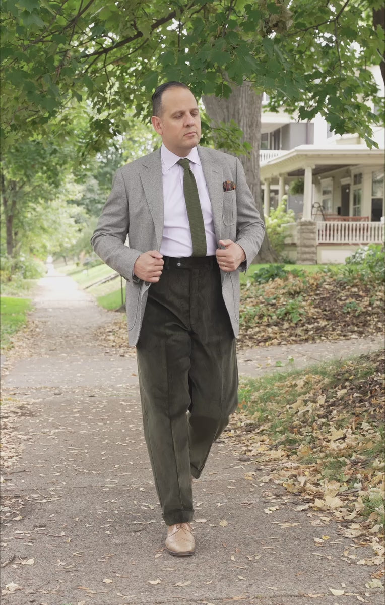 Lifestyle shot of Sven Raphael Schneider walking outside wearing a sport coat outfit with the Dark Olive Corduroy Trousers by Fort Belvedere