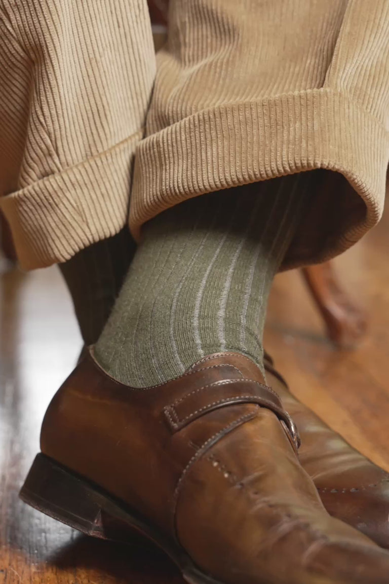 Looping video of a pair of shadow stripe socks in lifestyle settings