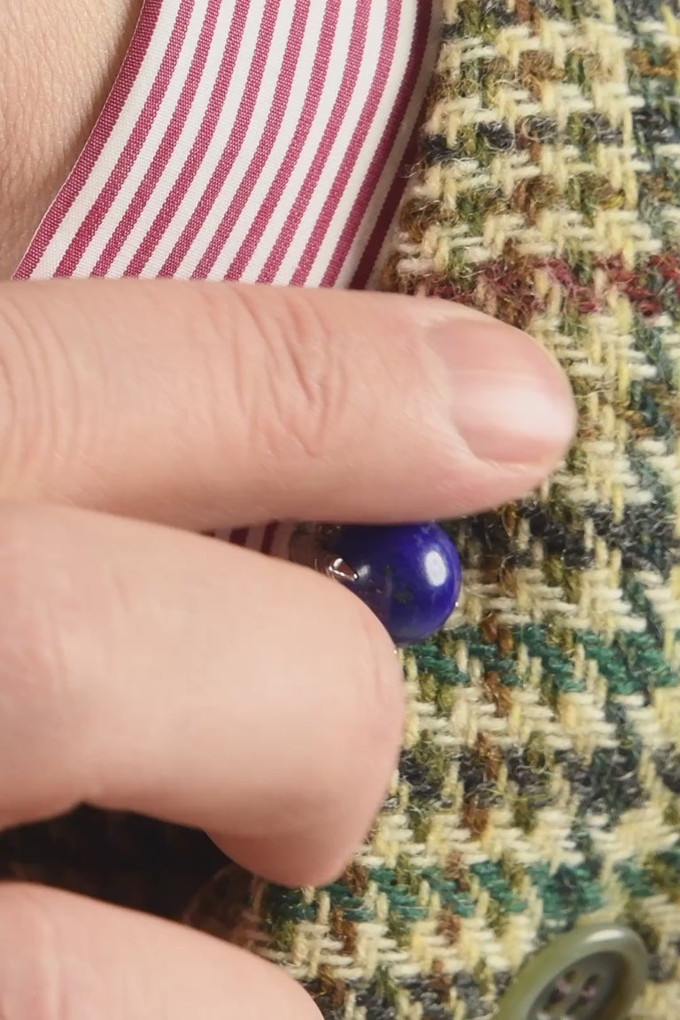 Looping video of silver colored eagle claw cufflinks holding balls