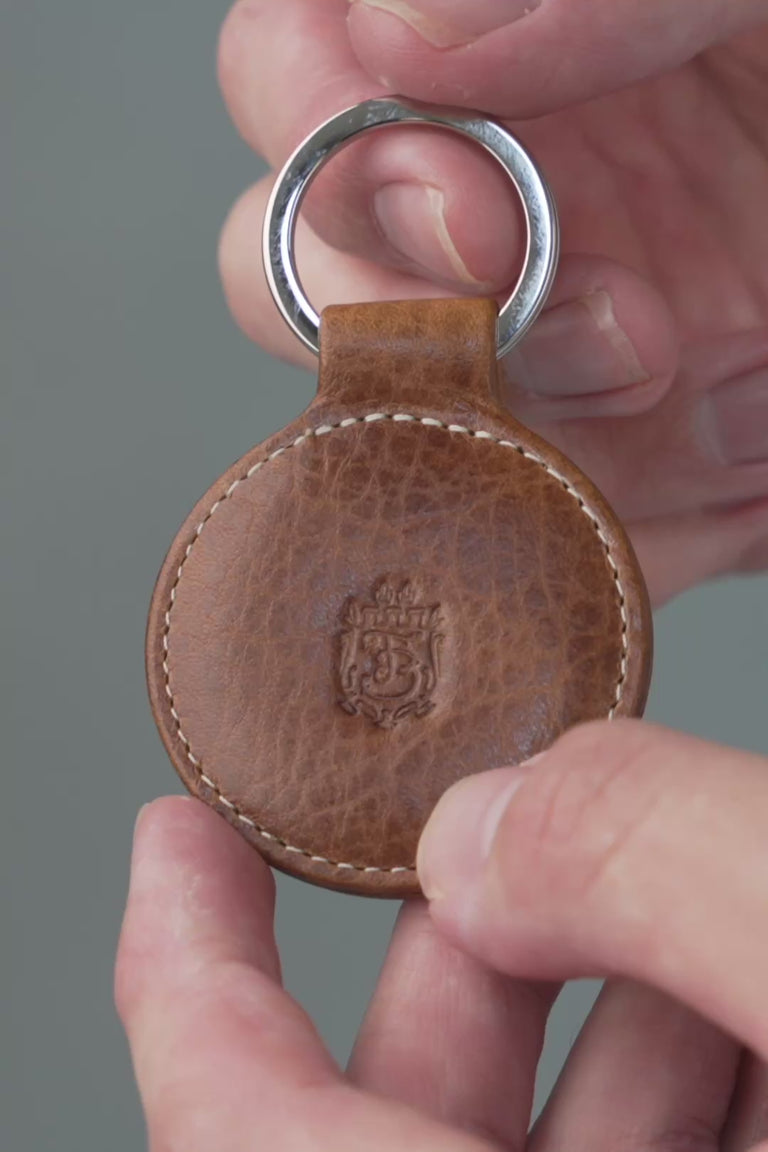 Looping video of a brown leather key fob. 