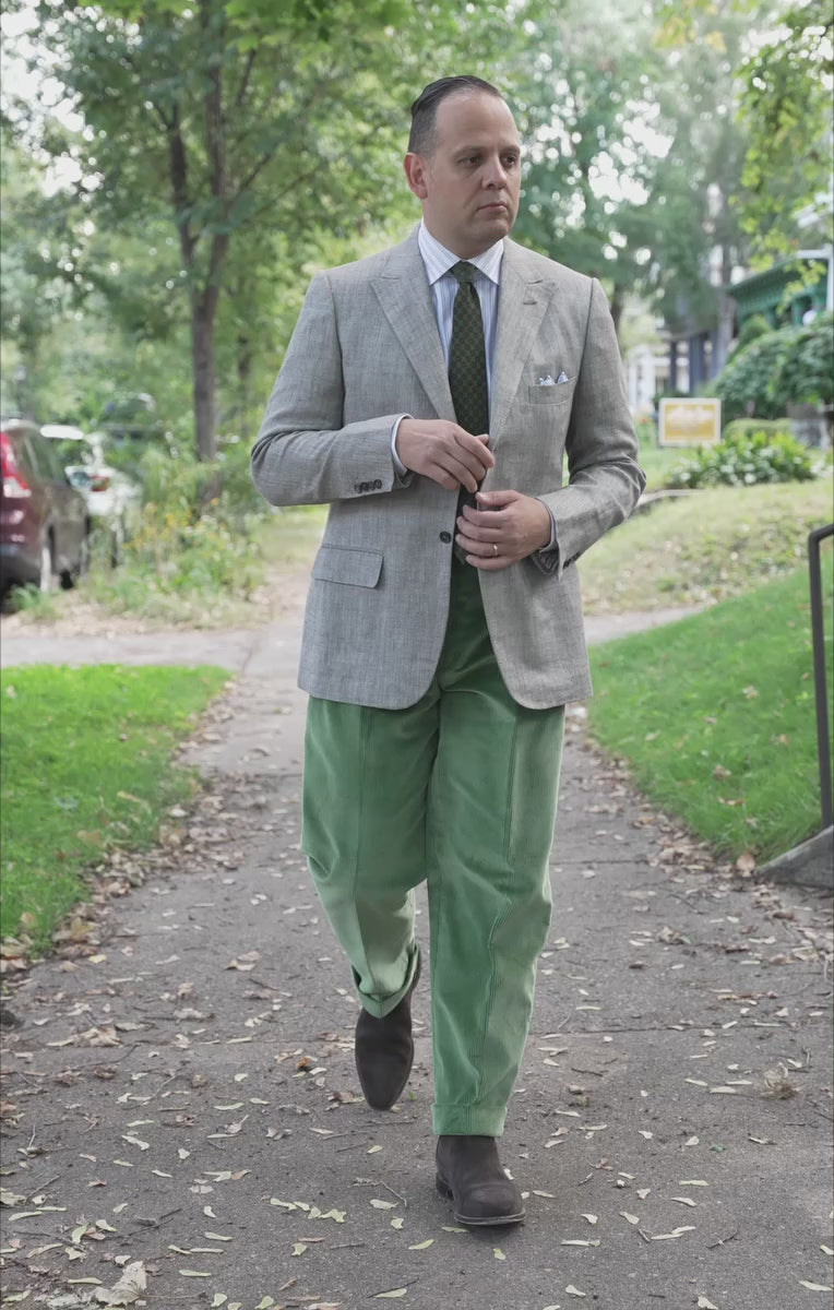 Lifestyle shot of Sven Raphael Schneider walking outside wearing a sport coat outfit with the Sage Green Corduroy Trousers by Fort Belvedere