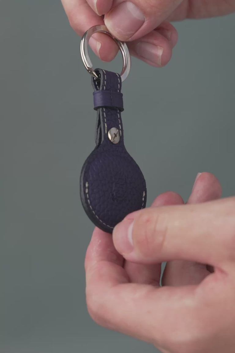 Looping video of a blue leather AirTag holder. 