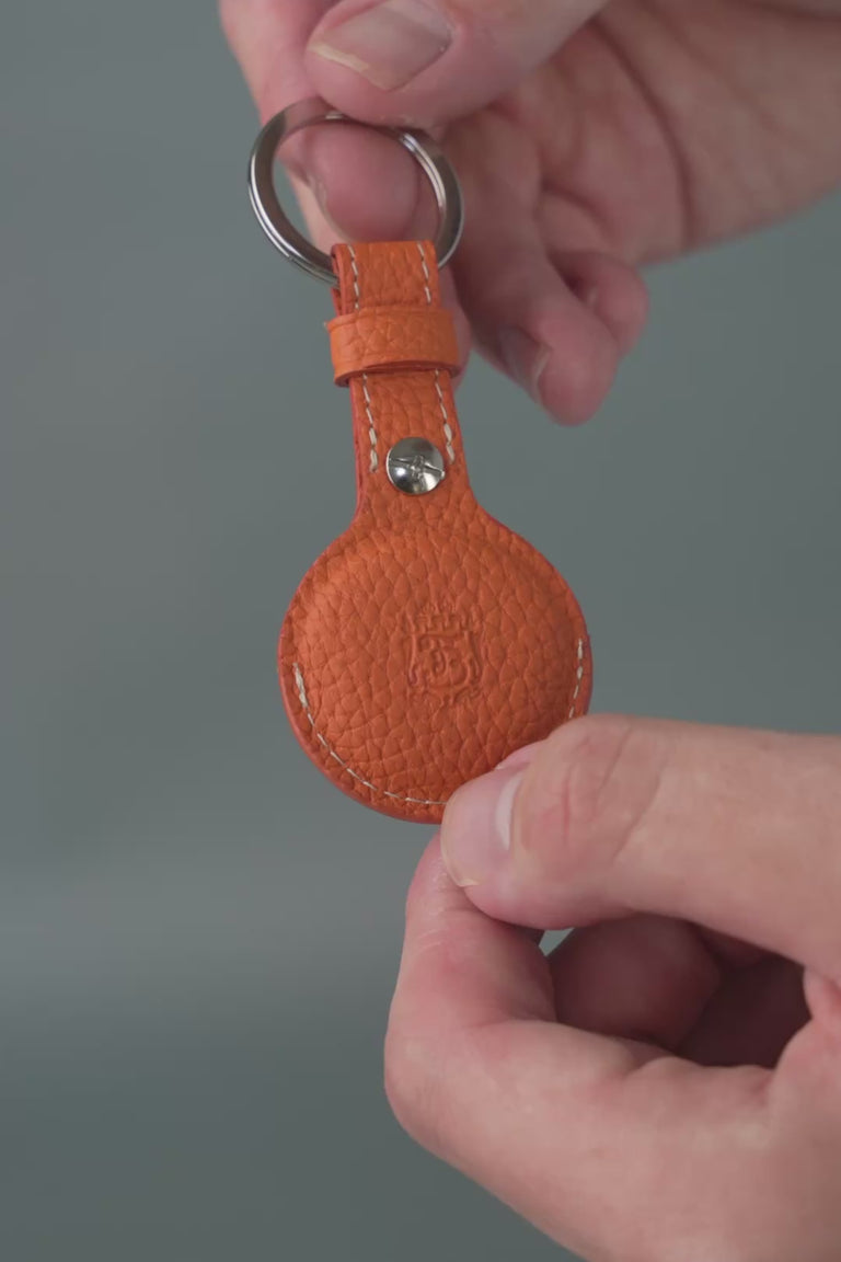 Looping video of an orange leather AirTag holder. 