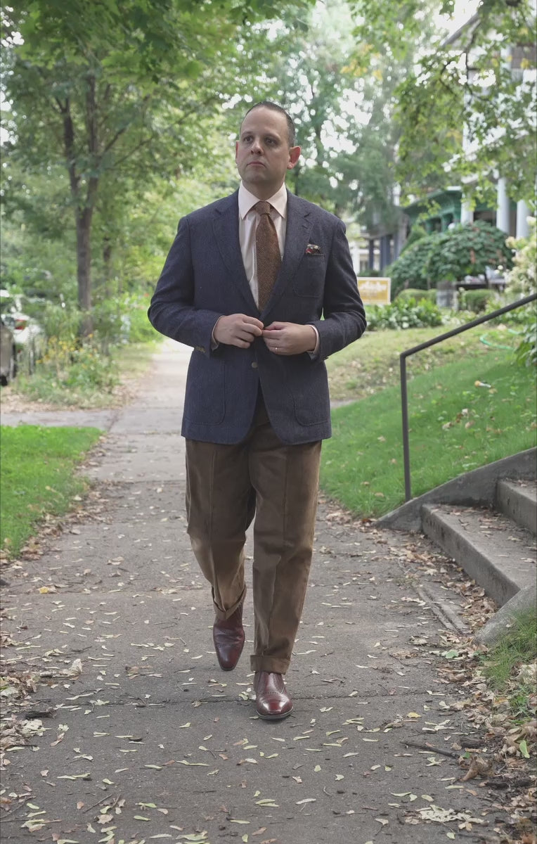 Lifestyle shot of Sven Raphael Schneider walking outside wearing a sport coat outfit with theCognac Corduroy Trousers by Fort Belvedere