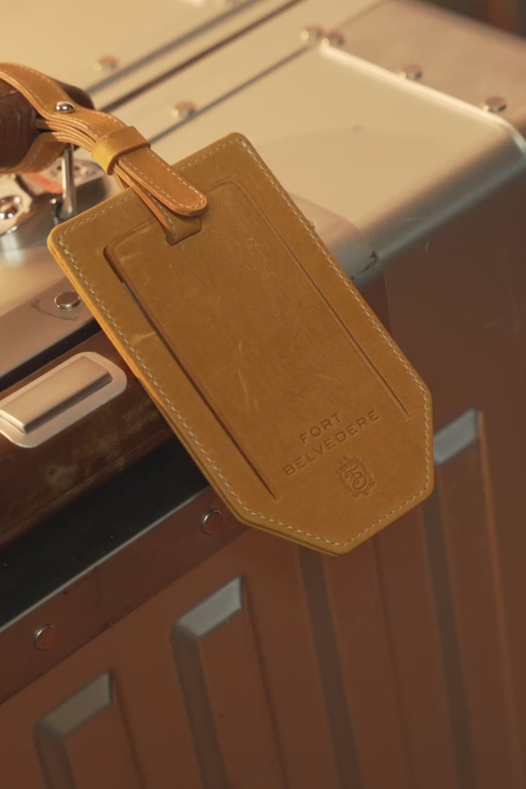 Looping video of a Fort Belvedere vintage gold americana leather luggage tag