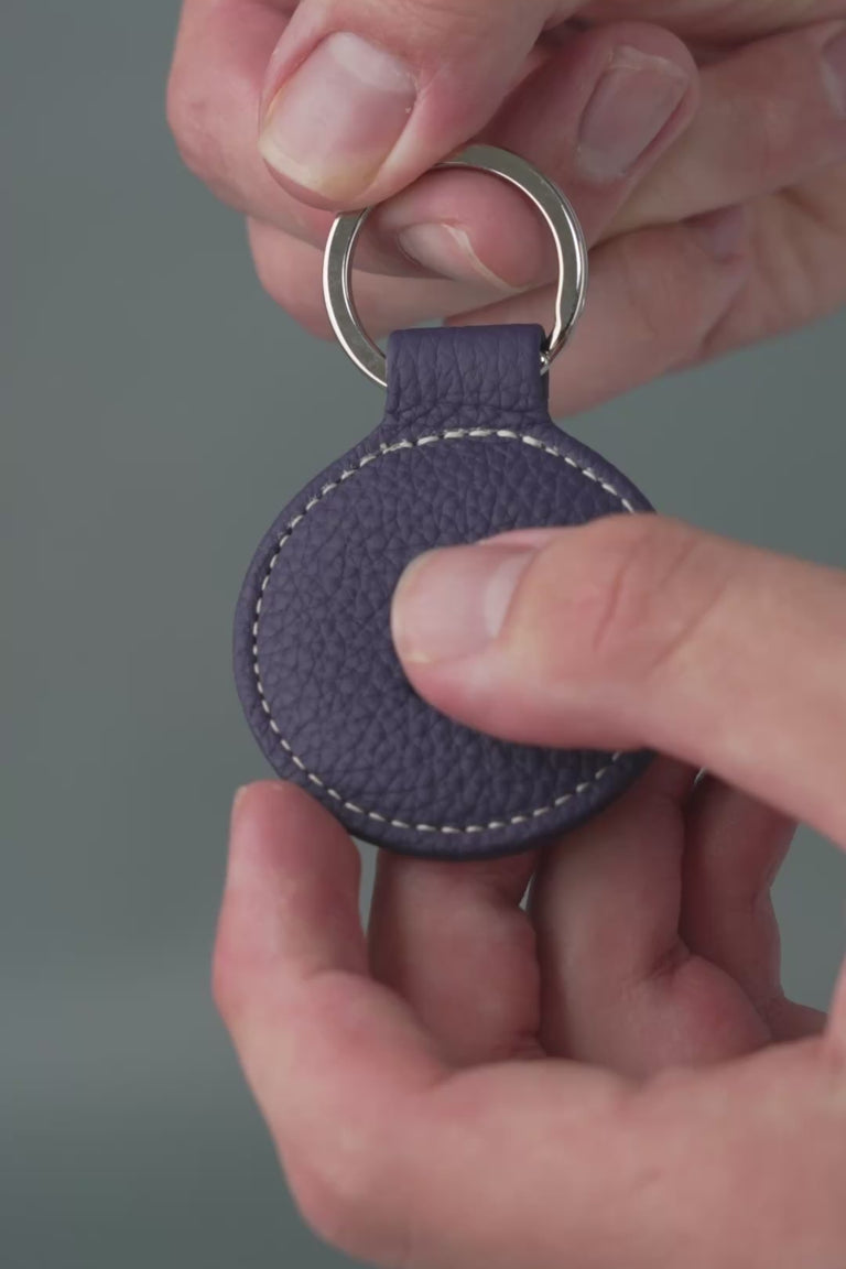 Looping video of a blue leather key fob. 