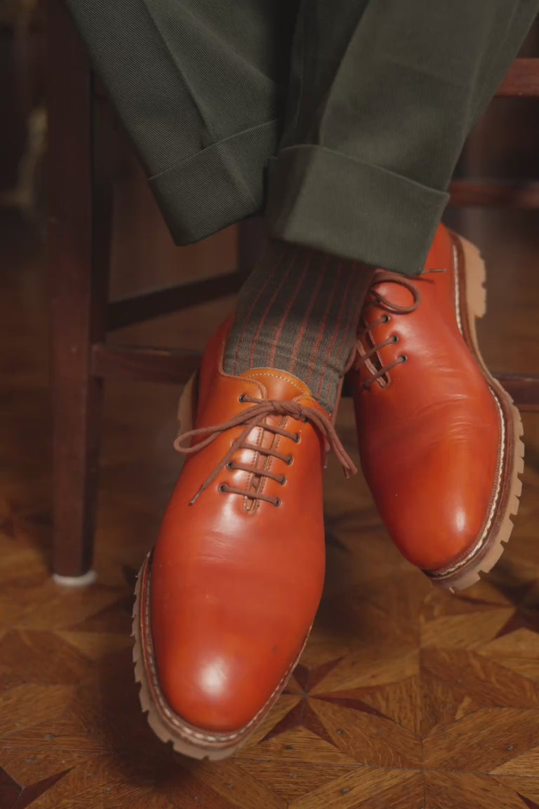 Looping video of a pair of shadow stripe socks in lifestyle settings