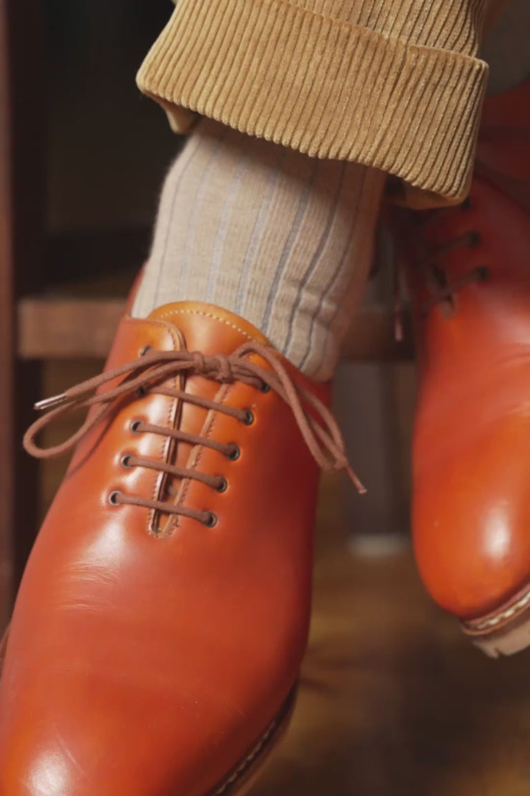 Looping video of a pair of shadow stripe socks in lifestyle settings