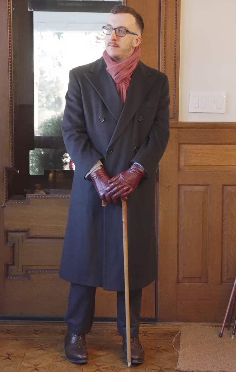 Orange red cashmere scarf worn with a navy overcoat