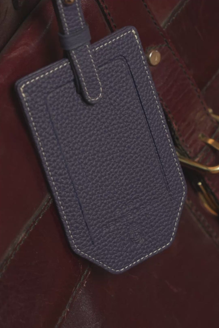 Looping video of a Fort Belvedere indigo blue leather luggage tag