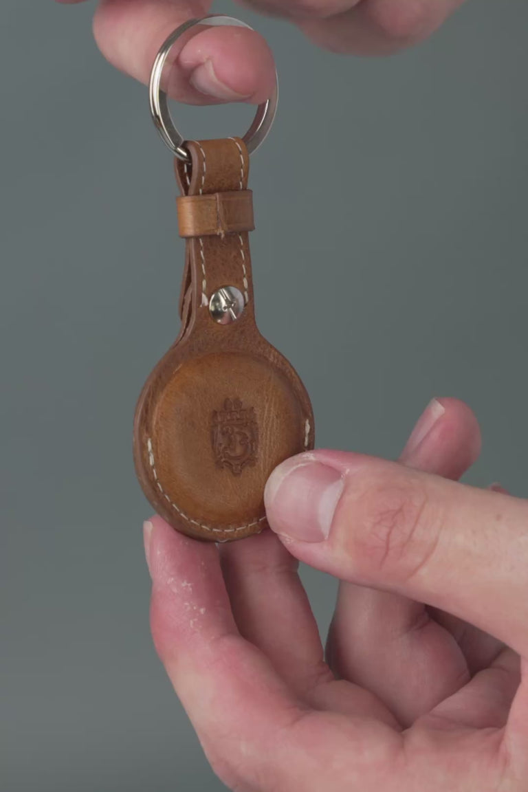 Looping video of a brown leather AirTag holder. 