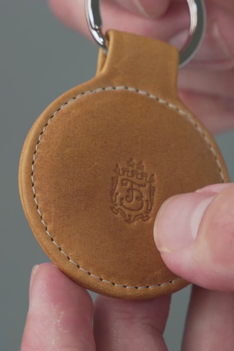 Looping video of a tan leather key fob. 