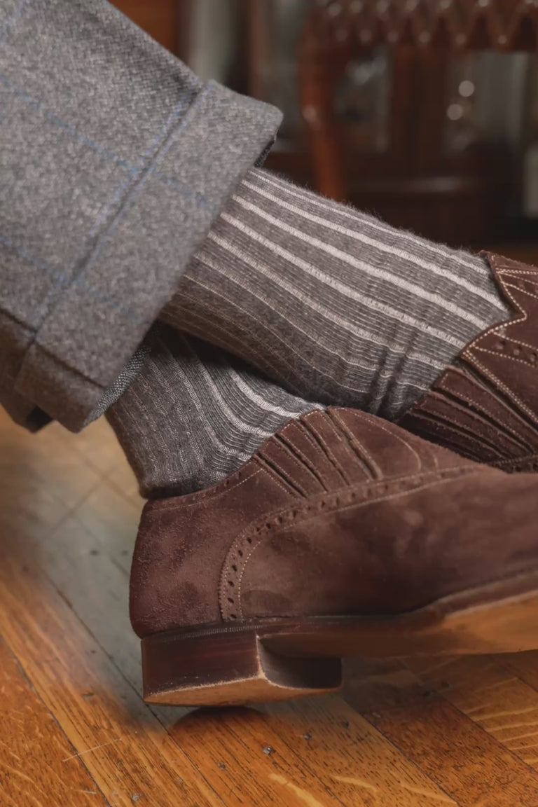 Looping video of a pair of shadow stripe socks in lifestyle settings