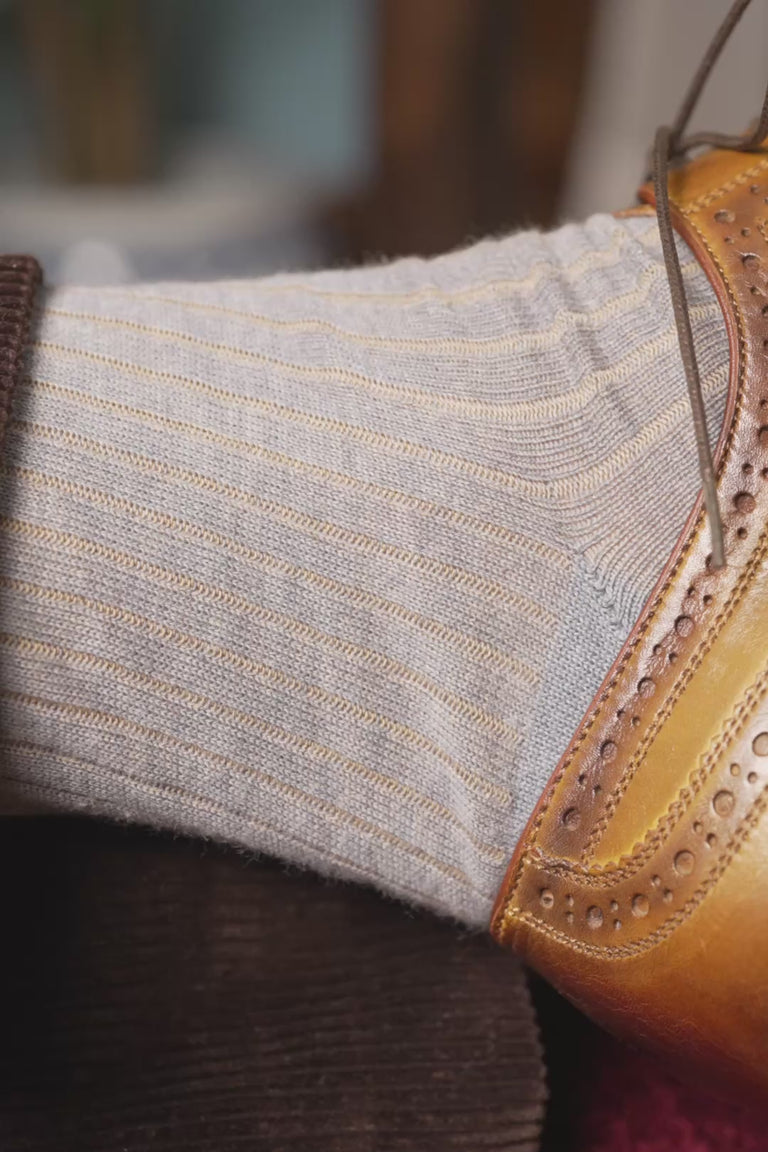 looping video of light gray and beige shadow stripe socks in lifestyle settings