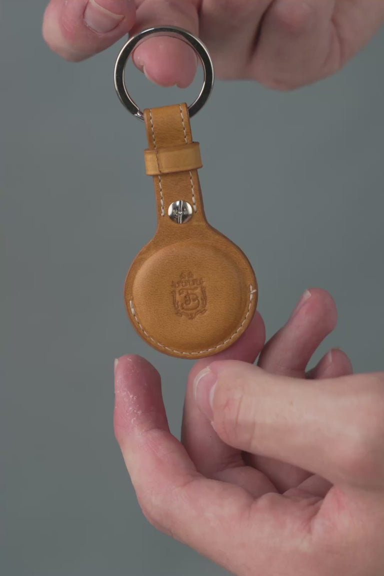 Looping video of a tan leather AirTag holder. 