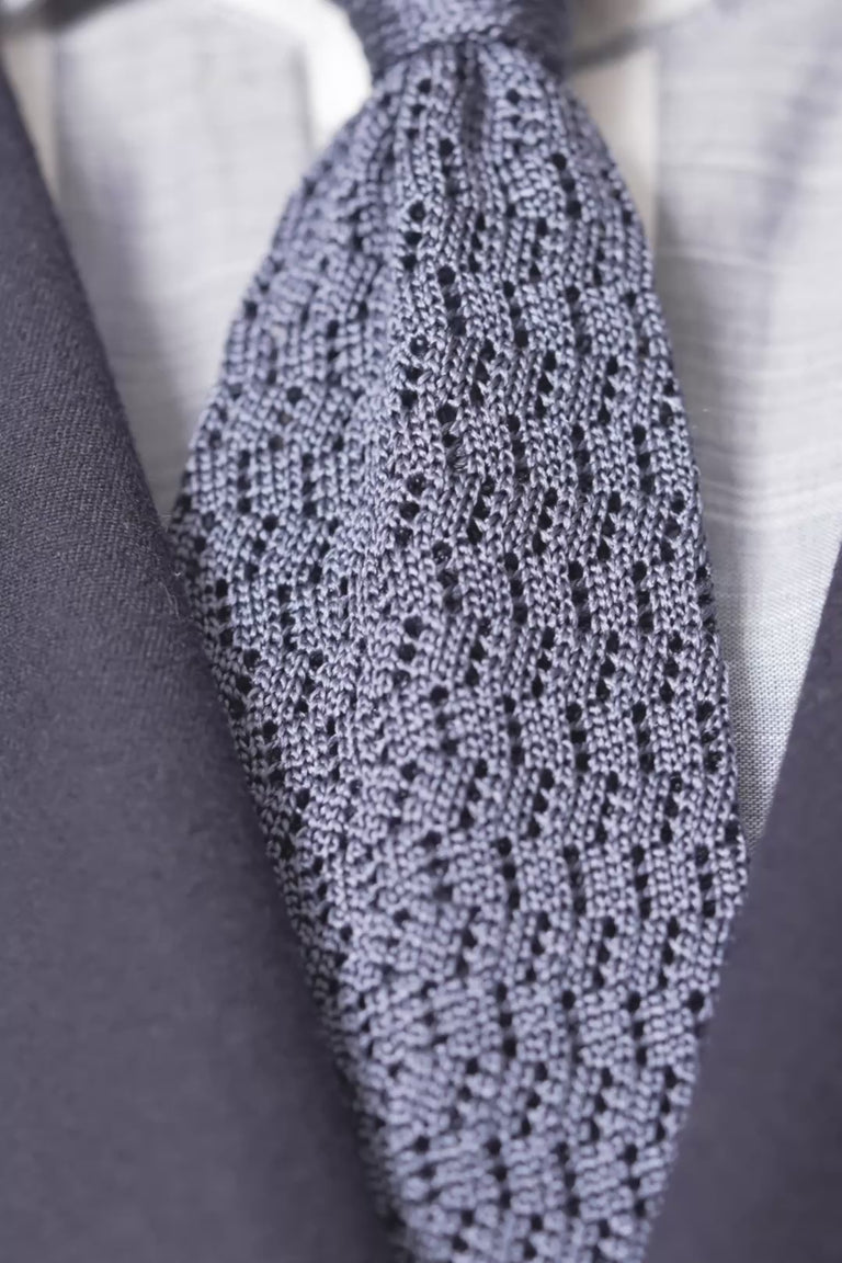 Looping images of a grayish blue silk knit zigzag tie
